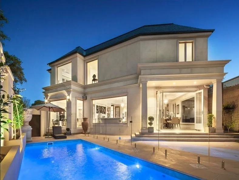 Rear elevation of the completed Kew residence with broad terrace, swimming pool and expansive glazed openings