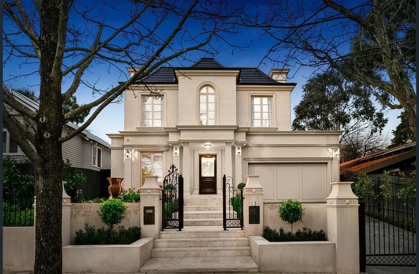 Tree-framed symmetrical front façade of the completed Camberwell Residence I at twilight