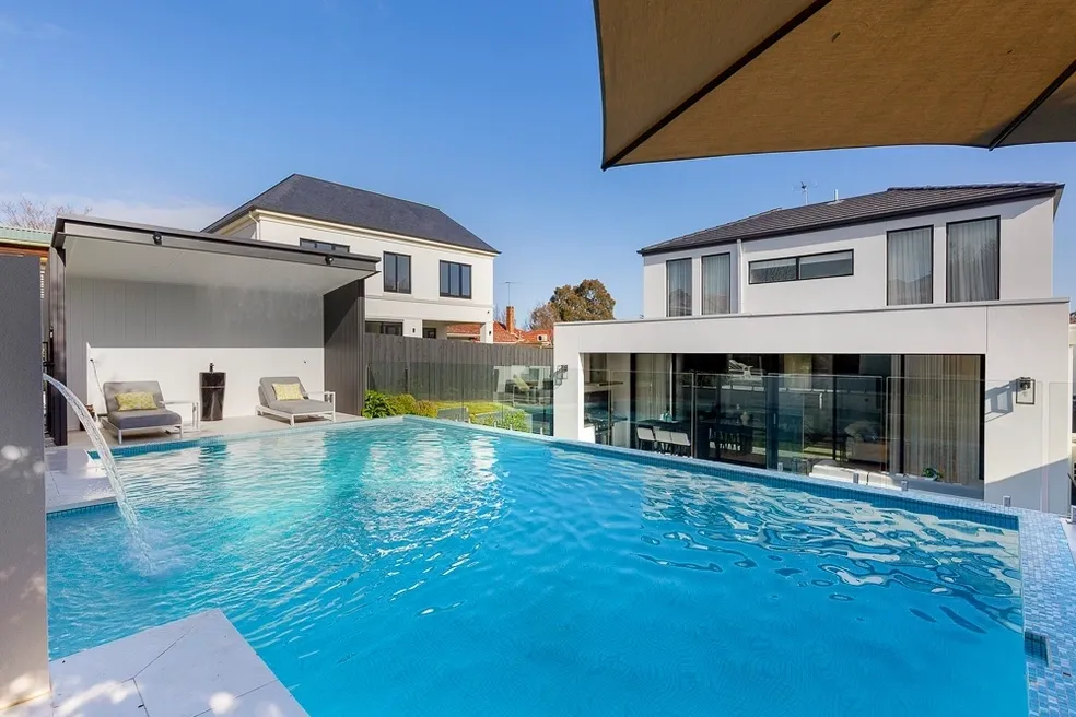 Elevated swimming pool and cabana at the completed Camberwell Residence II with contemporary rear elevation